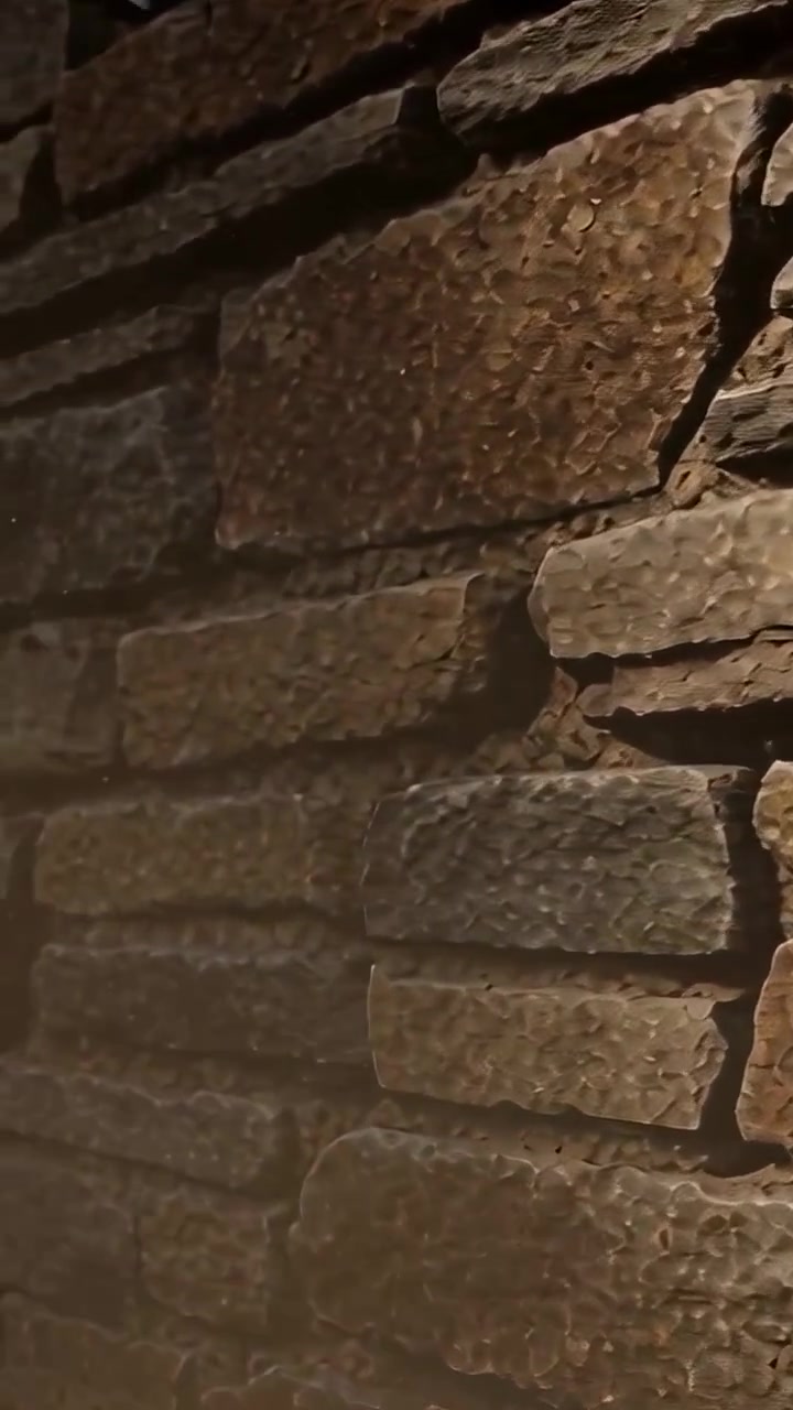 Vertical video: Panning camera revealing stacked stone wall in lobby under warm light showing chips