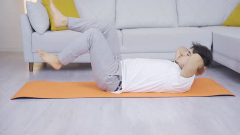 Man-lying-on-floor-doing-stretching-fitness-moves.