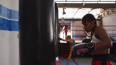 mixed race woman boxing in punchbag