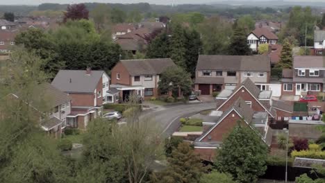 Quiet British homes and gardens residential suburban property aerial view pan right