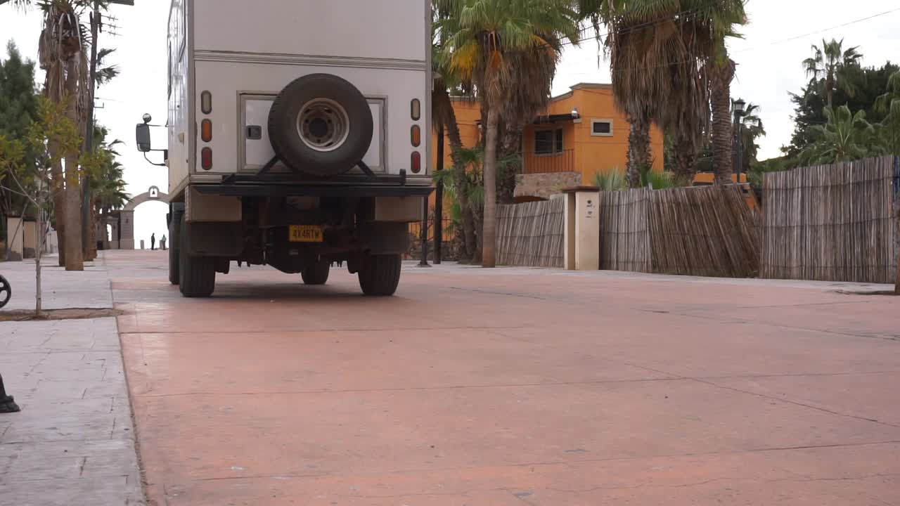 Ripresa dal basso di un grande camper che guida per le strade di una città messicana