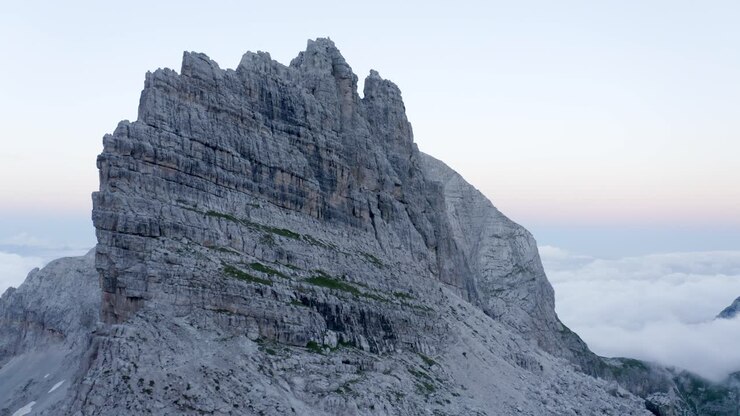 Luftaufnahme der felsigen Dolomitenberge mit schwebenden Wolken im Tal bei Sonnenuntergang – Brenta-Dolomiten in Italien.