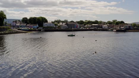 Aerial-dolly-shot-gracefully-glides-above-the-water,-nearing-the-town-center