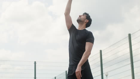 vista inferior del hombre moreno golpeando una pelota de voleibol.