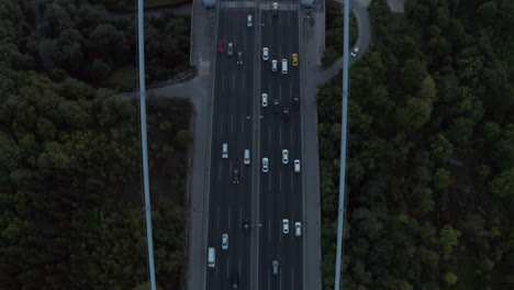 Cars-driving-onto-Bridge-towards-City-Skyline-in-Istanbul,-Turkey-over-Bosphorus,-Aerial-birds-eye-view-tilt-up