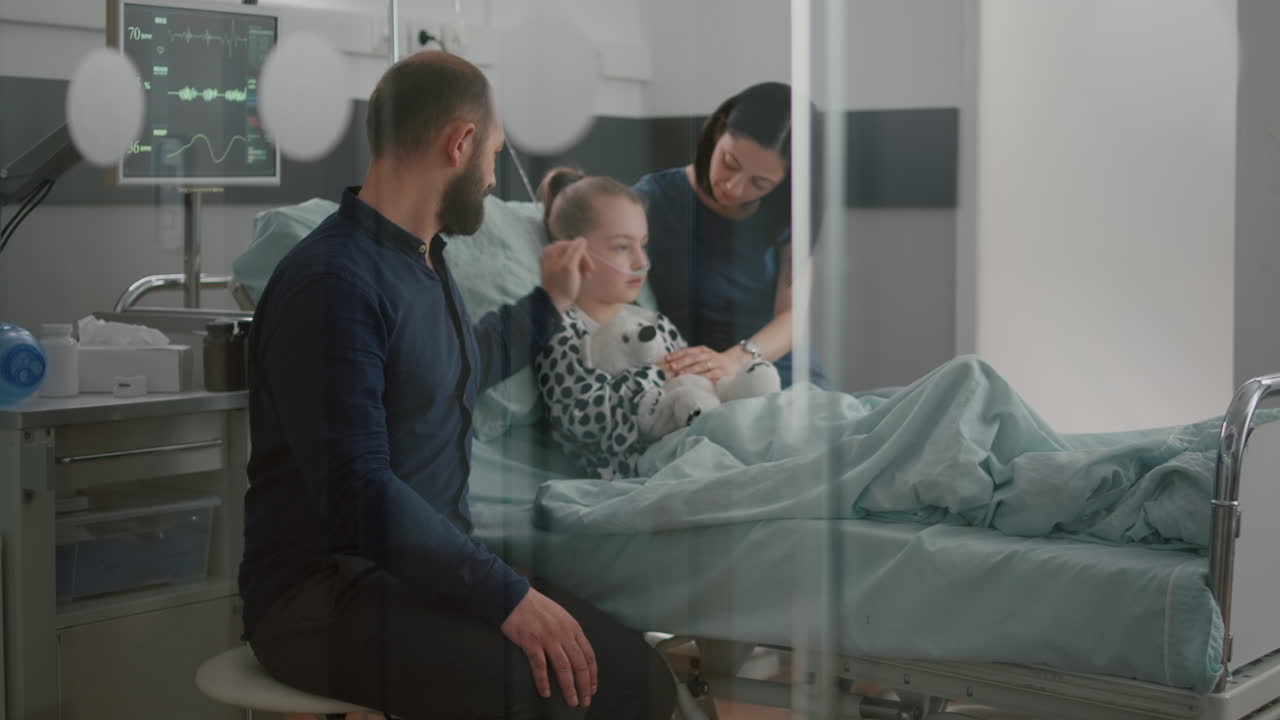 Sick daughter wearing oxygen nasal tube lying in bed after illness surgery