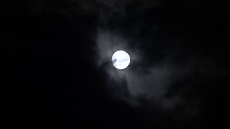 luna llena detrás de las nubes por la noche