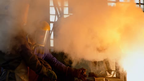 worker melting molten in container at foundry workshop 4k