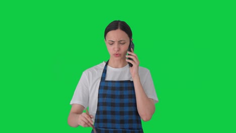 angry indian housewife shouting on call while making food green screen