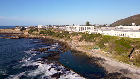 hermanus residents swim in marine tide pool on rugged coastline