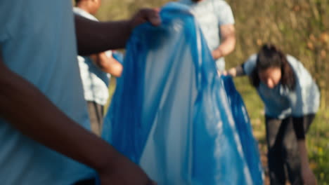 diverse volunteers collecting garbage and junk from the forest area