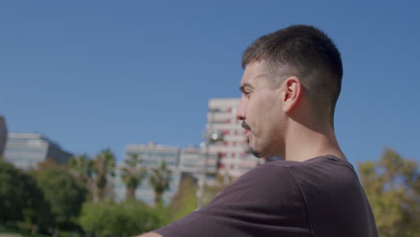 close-up of a young caucasian man drinking an isotonic drink on break from playing on a city street basketball court on a sunny day