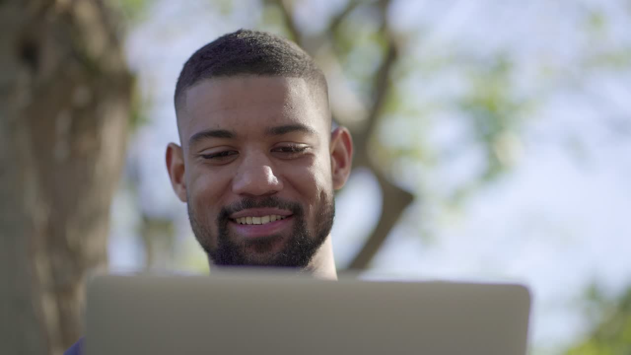 joven trabajando en una computadora portátil, recibiendo buenos resultados, exultando