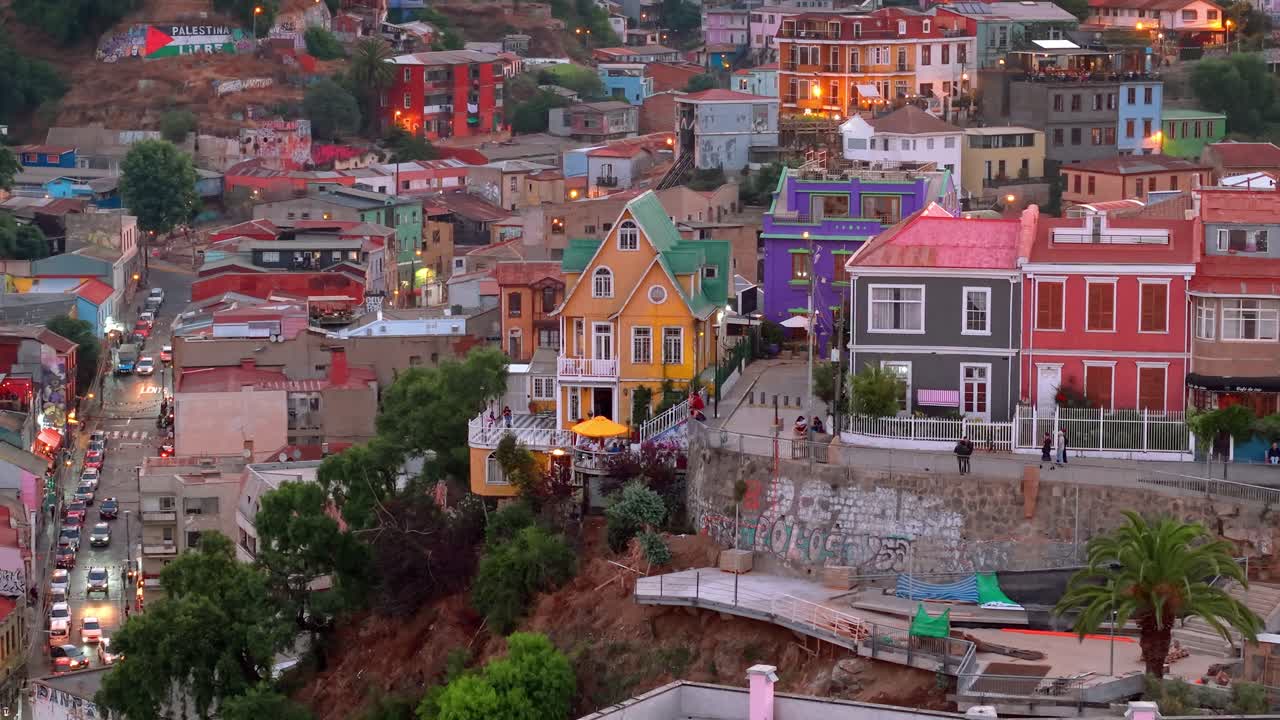 Bird's-eye view from orbit of the colorful architecture of the Atkinson promenade on Concepcion Hill at sunset with the lights of the hills lit up in the background. Valparaiso, Chile