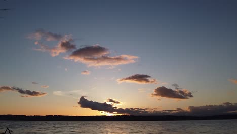 Beautiful hyper time lapse golden hour to blue to black clouds boiling sunset looking out over Puget Sound, zoom out pan right