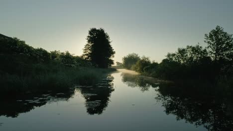 drone pov forward low on river waters running through countryside