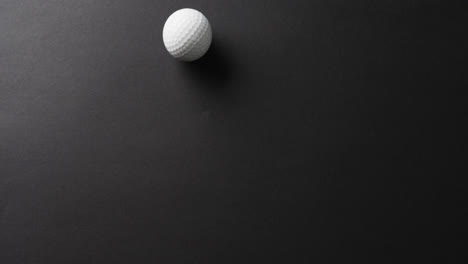 Primer-Plano-De-Una-Pelota-De-Golf-Sobre-Fondo-Negro,-Espacio-Para-Copiar,-Cámara-Lenta