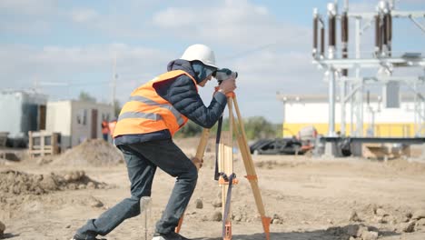 an engineer surveyor takes measurements at the construction of a transformer substation