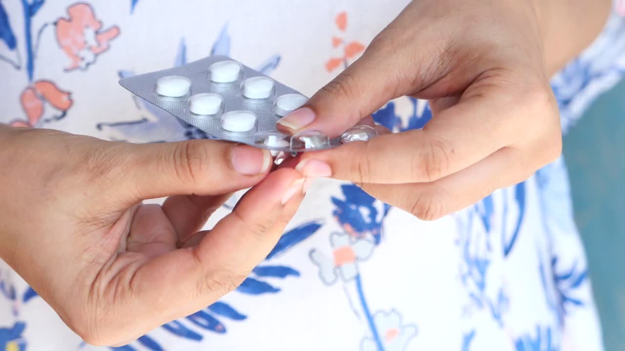 mujer que toma medicamentos: pastillas y cápsulas