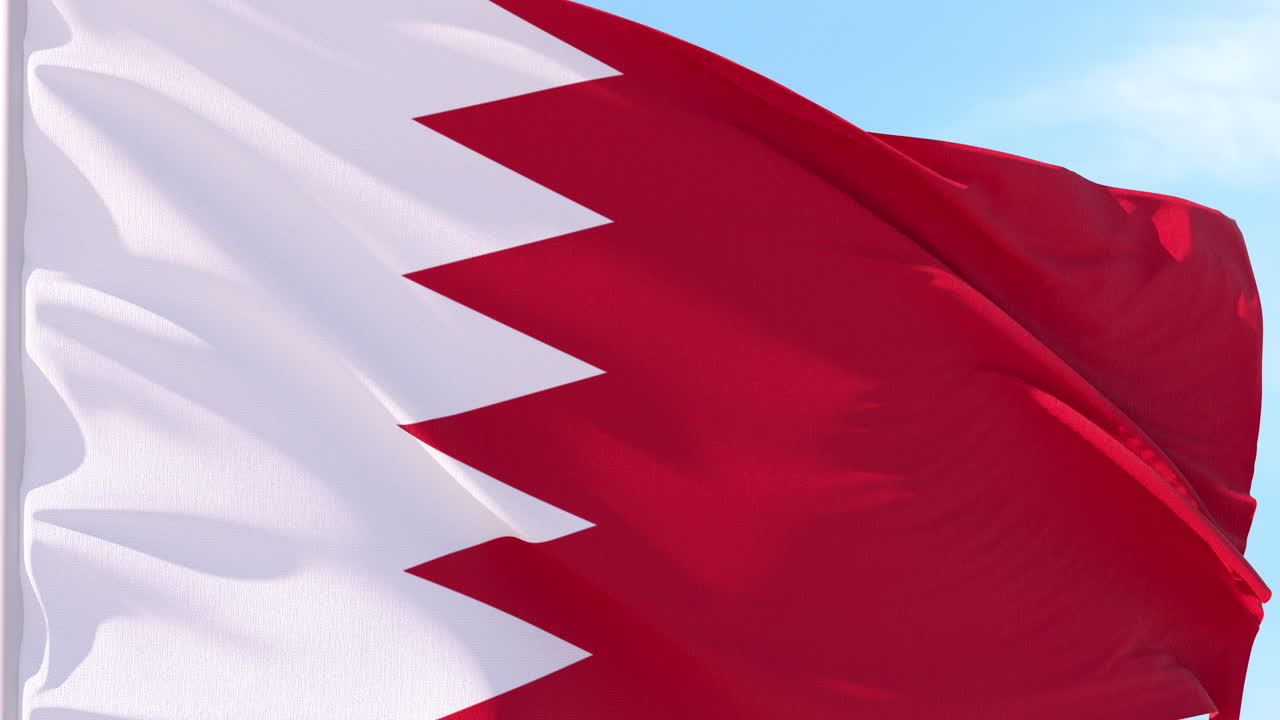 Bandiera del Bahrain che sventola al vento contro il cielo blu