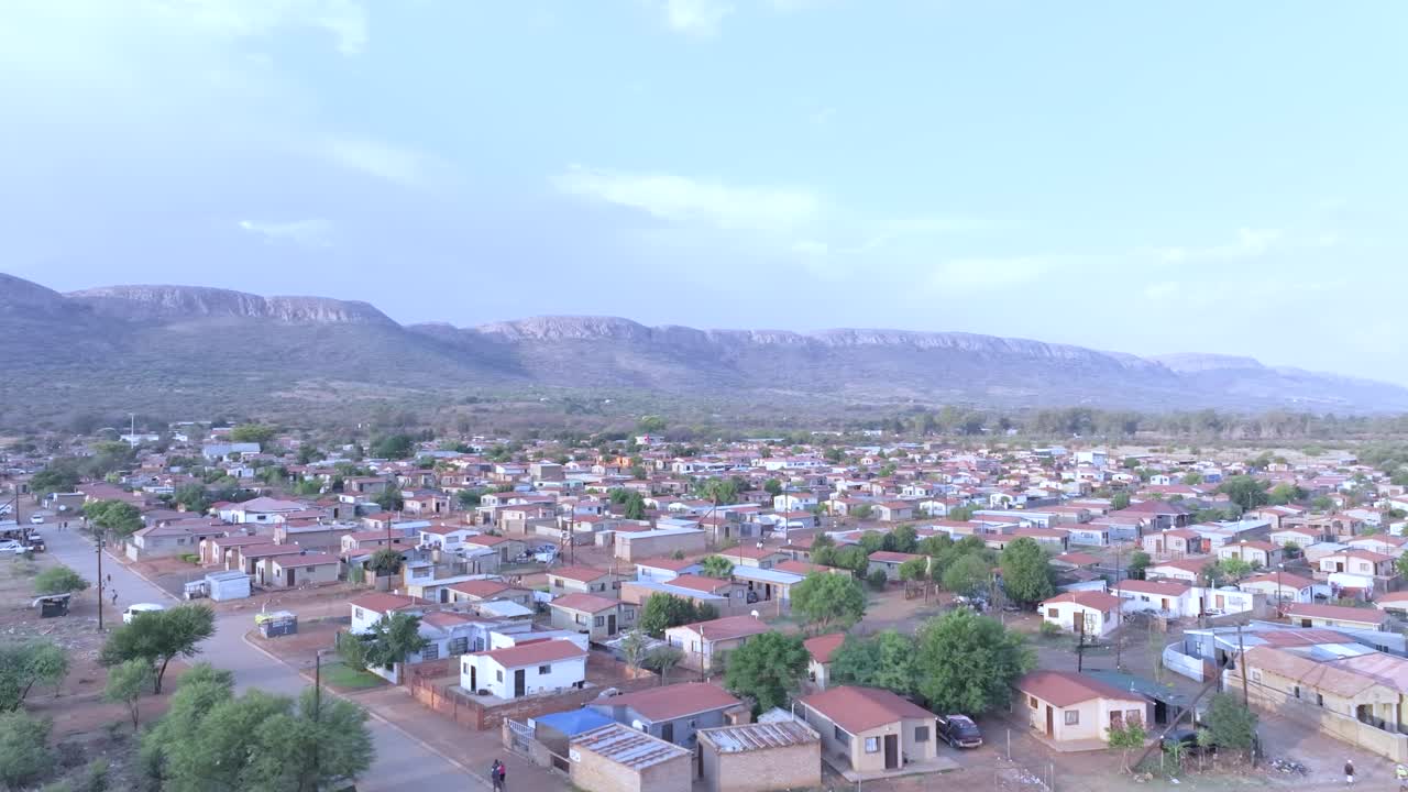 A township in midrand, south africa with houses and surrounding mountains, aerial view