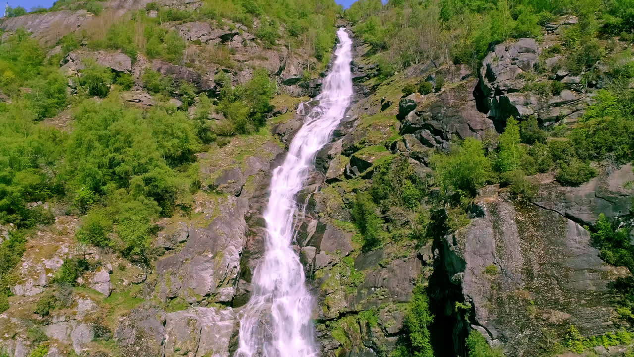agua cayendo sobre una cascada alta escondida entre la naturaleza verde