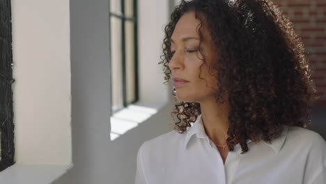 mature-mixed-race-woman-drinking-coffee-at-home-enjoying-relaxed-morning-looking-out-window-thinking-contemplative