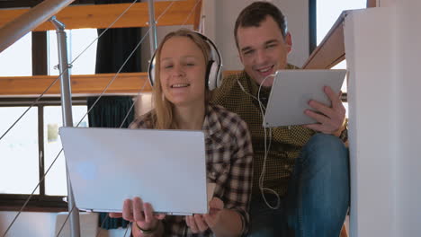 una pareja joven en heaphones en casa disfrutando de la música