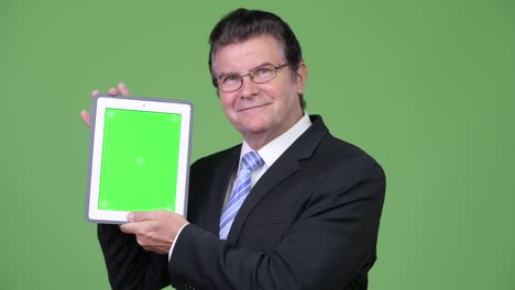 un hombre de negocios muy guapo mostrando una tableta digital.