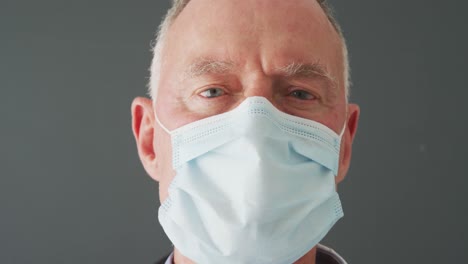 Close-up-of-portrait-of-caucasian-senior-male-doctor-wearing-face-mask