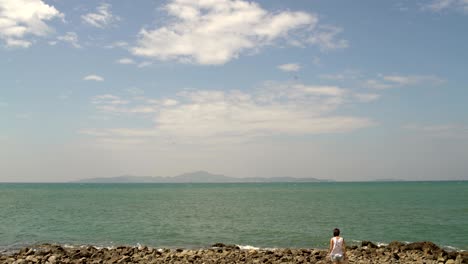 a woman goes on the rocks near the sea