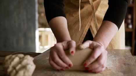 Close-Up-Footage-Of-Female-Hands-With-Beautiful-Red-Manicure-Holding-Clay-And-Kneading-It-On-A-Worktop-1