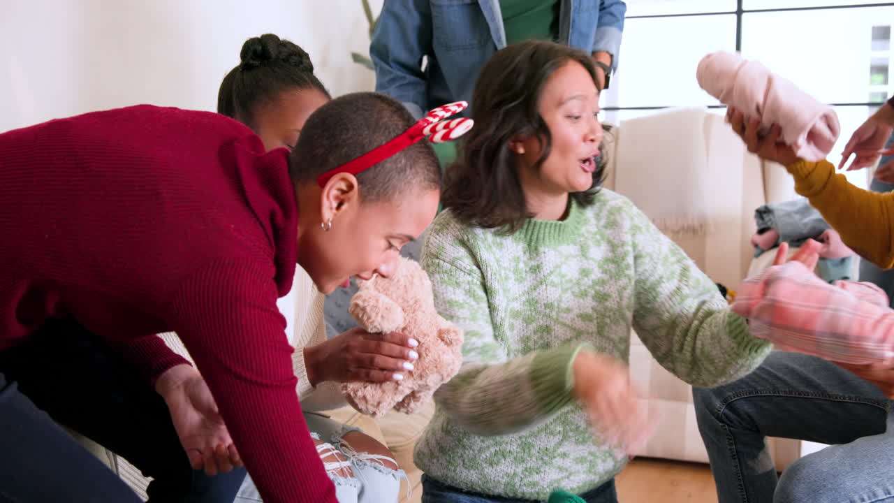 At Christmas, diverse friends exchanging gifts and enjoying holiday spirit at home together