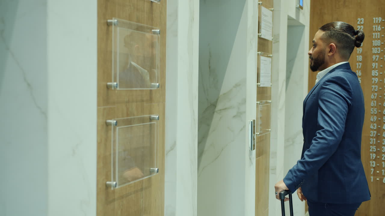 Businessman waiting for elevator in a modern hotel lobby