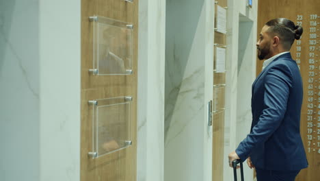 businessman waiting for elevator in a modern hotel lobby