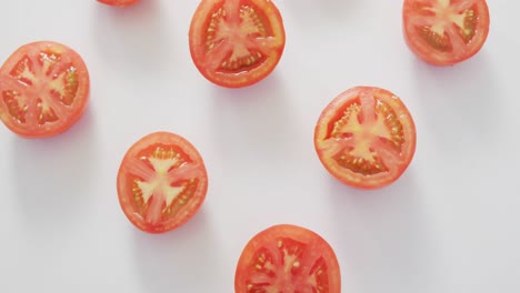 video de tomates rojos recién cortados por la mitad sobre un fondo blanco