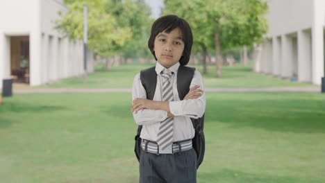 Confident-Indian-school-boy-standing-crossed-hands