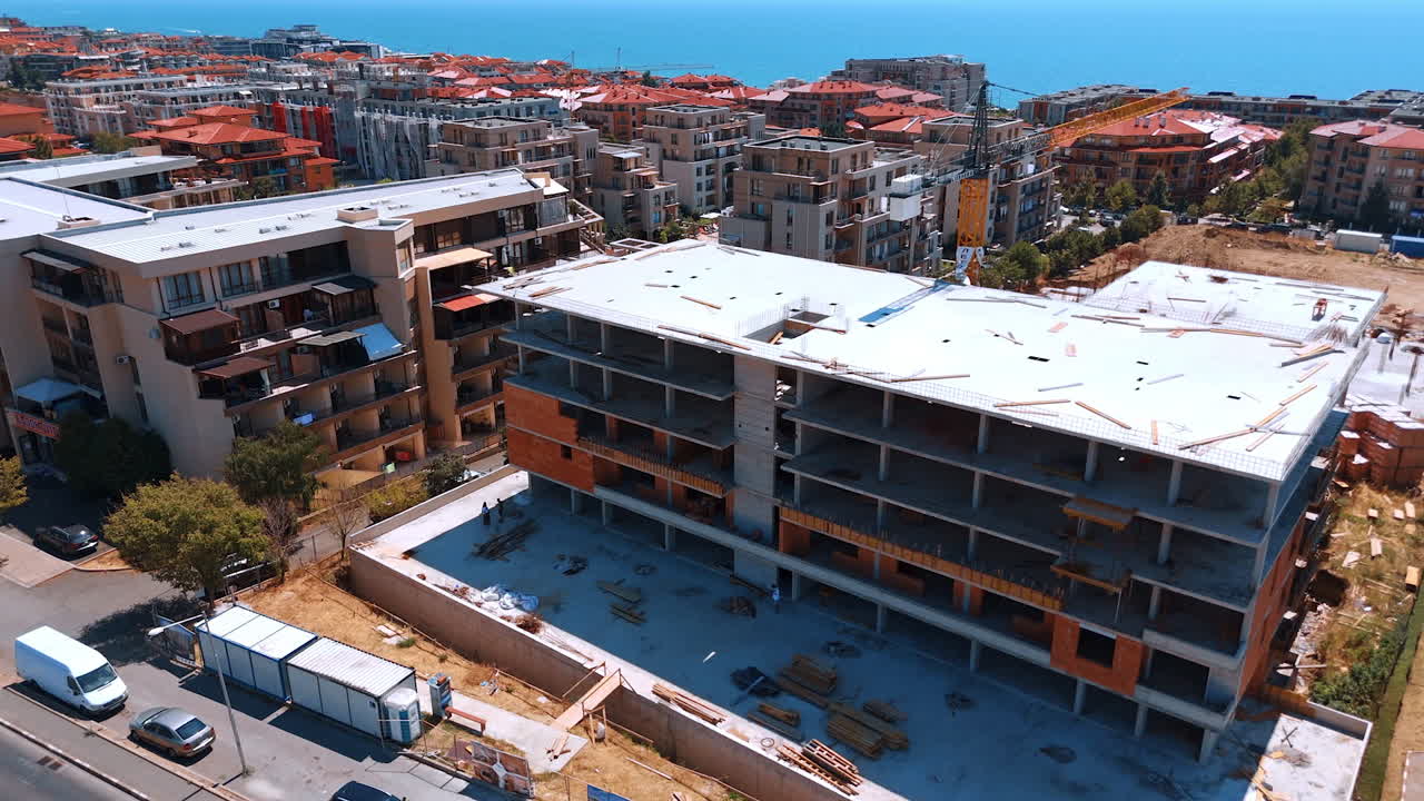 Varna, Bulgaria, 11 July 2025: Construction project near coastal area. Workers are busy at a construction site for a new building overlooking the sea in a busy urban area