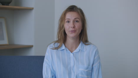 Curly-hair-young-woman-talking.-woman-having-a-job-interview.-teen-girl-blogger-vlogger-doing-online-video-chat-call-record-vlog-blog-talking-to-camera-looking-at-webcam-indoors-at-home