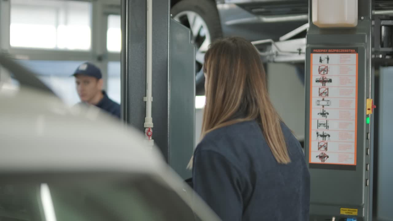 Female Manager Discussing Vehicle Repair with Mechanic in Auto Repair Shop