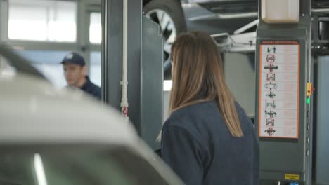 female manager discussing vehicle repair with mechanic in auto repair shop