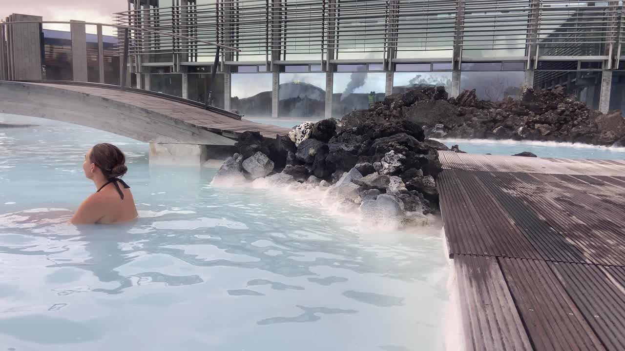 Young attractive girl relaxing in the thermal waters of Blue Lagoon spa