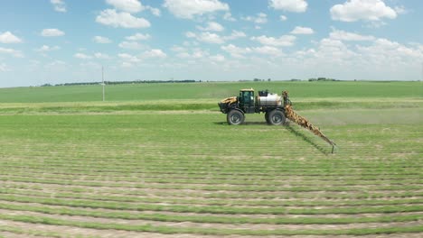 aerial, farm tractor spraying pesticides on crops
