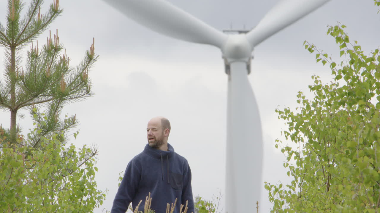 TURBINE EOLICHE - Un uomo sulla quarantina si toglie il cappello mentre si prende una pausa dalla camminata