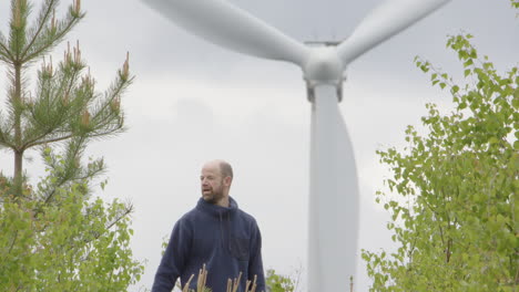 wind turbines - a man in his 40s removes his hat having a break from the walk