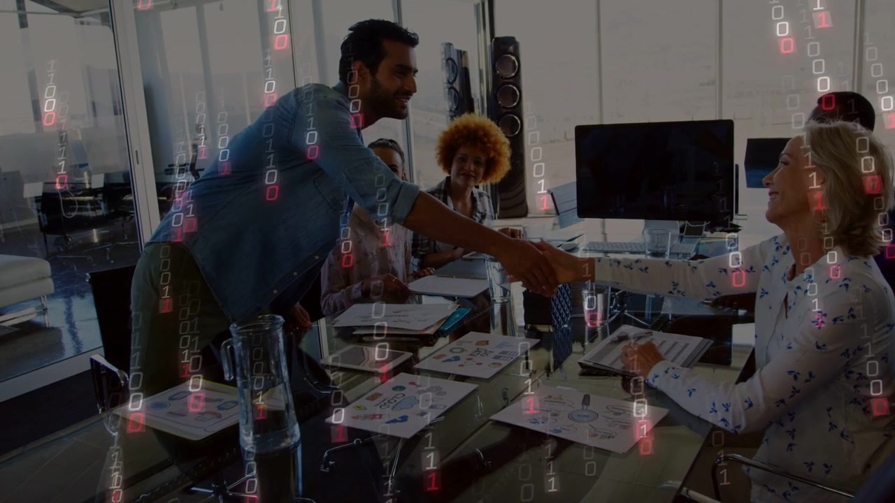 Man leaning starting handshake across glass table, team noting charts, falling bits over biz launch
