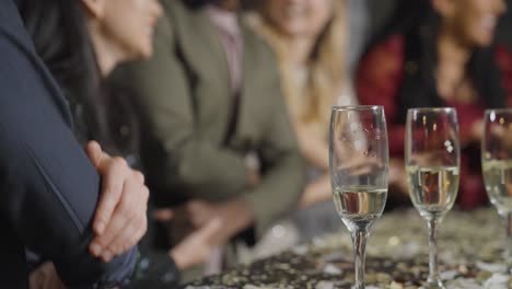 close up shot of friends performing auld lang syne during new year's eve celebrations