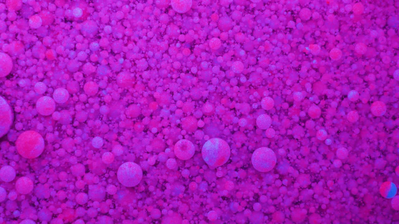 Slow Motion Bright Neon Color Bubbles Oil Beautiful Fluorescent Paint Sparkling Color Moving Multicolor Close up. Acrylic Neon Paint. Fantastic Surface. Abstract Colorful Transformation Gravitation.