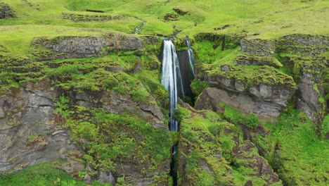 gljufrabui waterfall hidden in cave during summer in iceland - aerial pullback