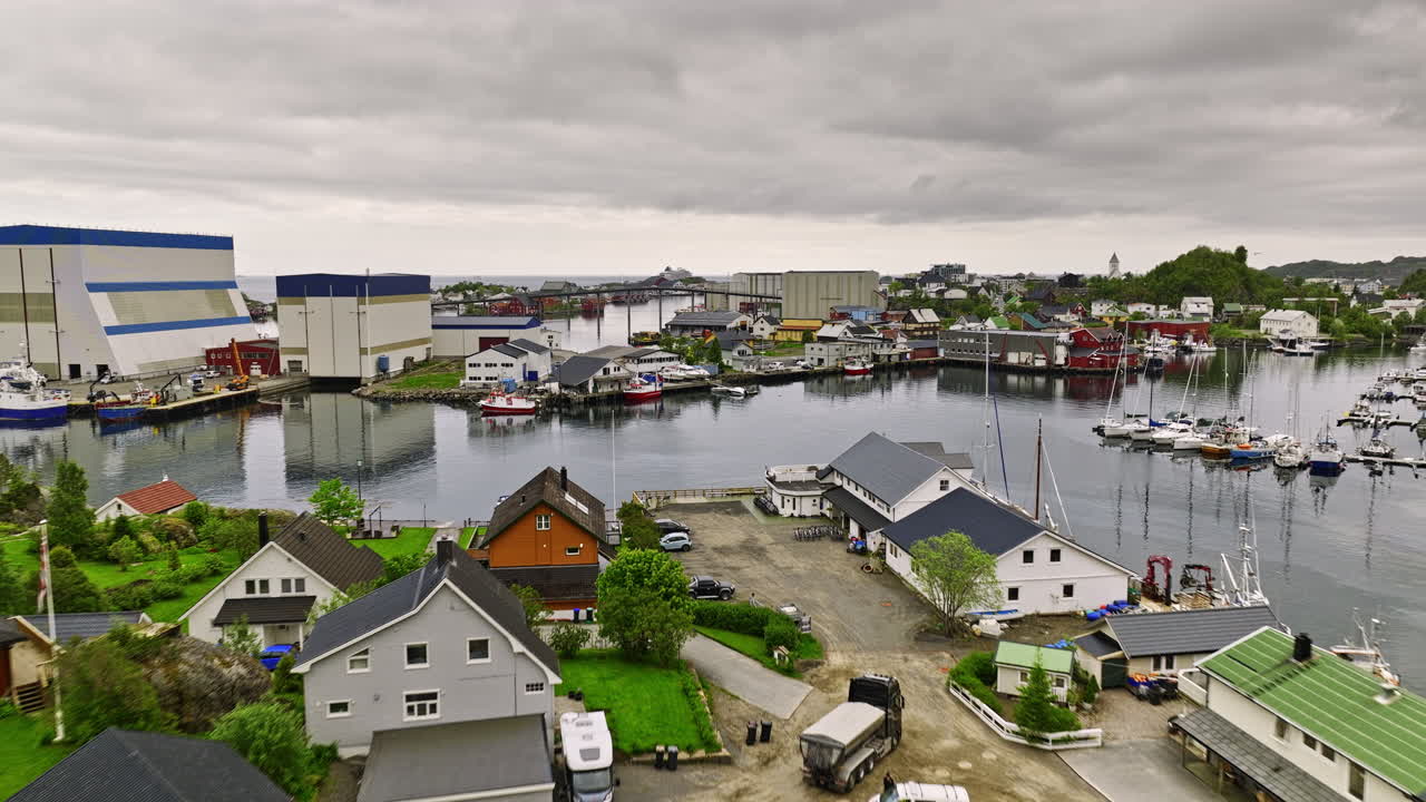 svolvær noruega v1 cinemático drone de bajo nivel sobrevuela el vecindario frente al mar capturando el rorbuer rojo situado en una pequeña isla en el puerto cerca del centro de la ciudad - filmado con mavic 3 cine - junio de 2022